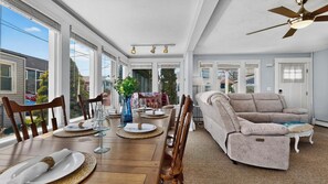 Un comedor con mesa de madera, sillas y un sofá.