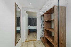 Een slaapkamer met een bed, een kledingkast en een spiegel.