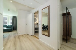 Un interior moderno con piso de madera, un espejo grande y una escalera.