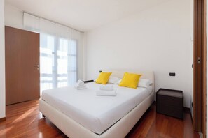 Ein Hotelzimmer mit einem Bett, einem Nachttisch und Holzboden.