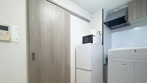 Una cocina compacta equipada con microondas, refrigerador y horno integrado.