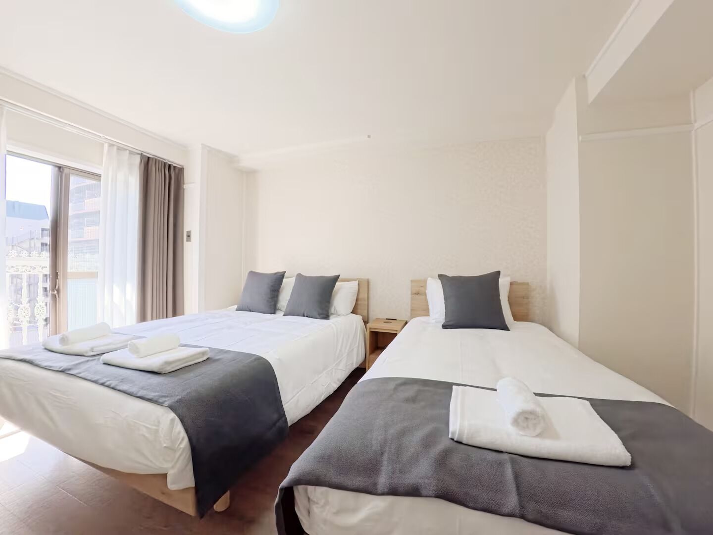 Une chambre d’hôtel avec deux lits, un balcon et une vue sur la ville.