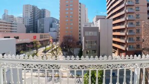Un paisaje urbano con edificios modernos, un edificio rojo destacado y una valla blanca.