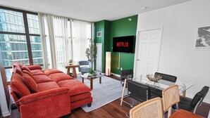 Ein modernes Wohnzimmer mit einem roten Sofa, einem Glastisch und einer grünen Wand.