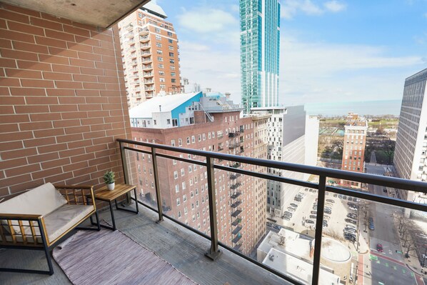 A balcony with a view of a cityscape, including tall buildings and a parking lot. - 21st Floor Skyline 2BR Grant Park and Field Museum (Chicago)