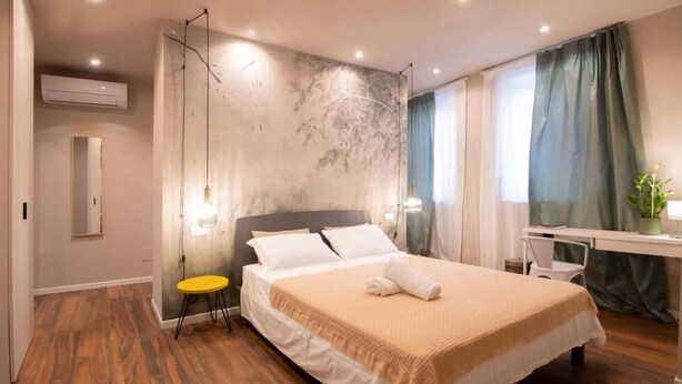Una habitación de hotel moderna con una cama grande, un escritorio y una silla.