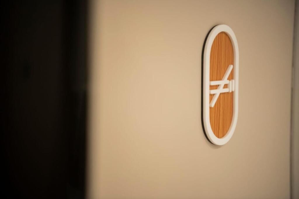 Une enseigne murale avec un fond en bois et un texte blanc.
