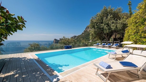 Une piscine avec des chaises longues et une terrasse en bois.