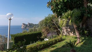 Un paysage côtier offrant une vue dégagée sur la mer, avec un lampadaire et une végétation luxuriante.