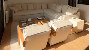 Una sala moderna con un sofá seccional, una mesa de centro y una lámpara colgante.