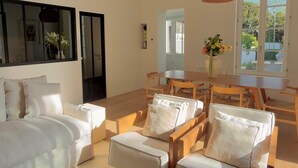 A spacious living area with a large sofa set, a wooden coffee table, and a dining table. - Maison Vicoli, completely new & renovated, Les Portes en Ré, Île de Ré! (Les Portes-en-Ré)
