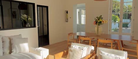 Un salón amplio con un gran sofá, una mesa de centro de madera y una mesa de comedor.