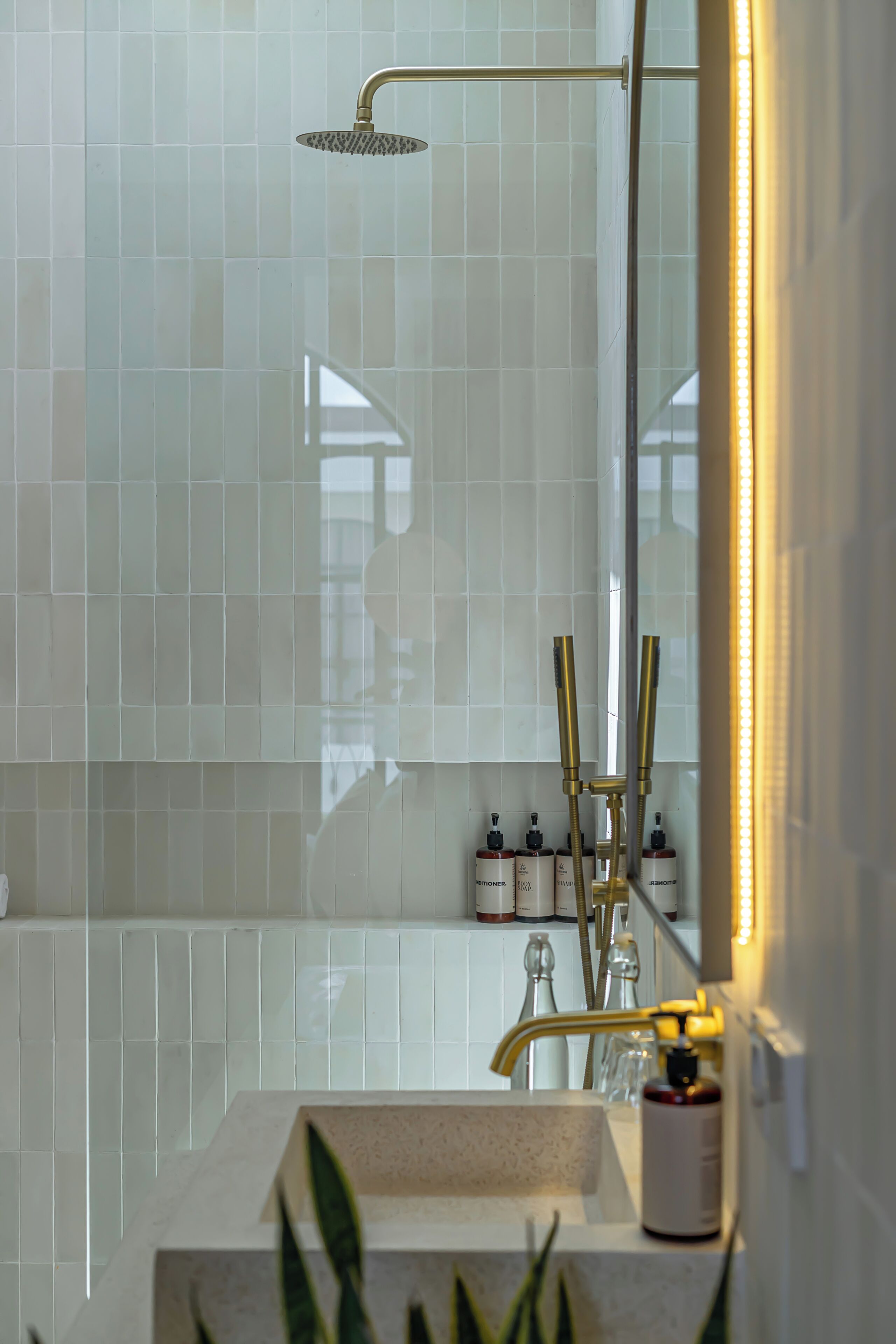 A bathroom with a shower, a sink, and a mirror.