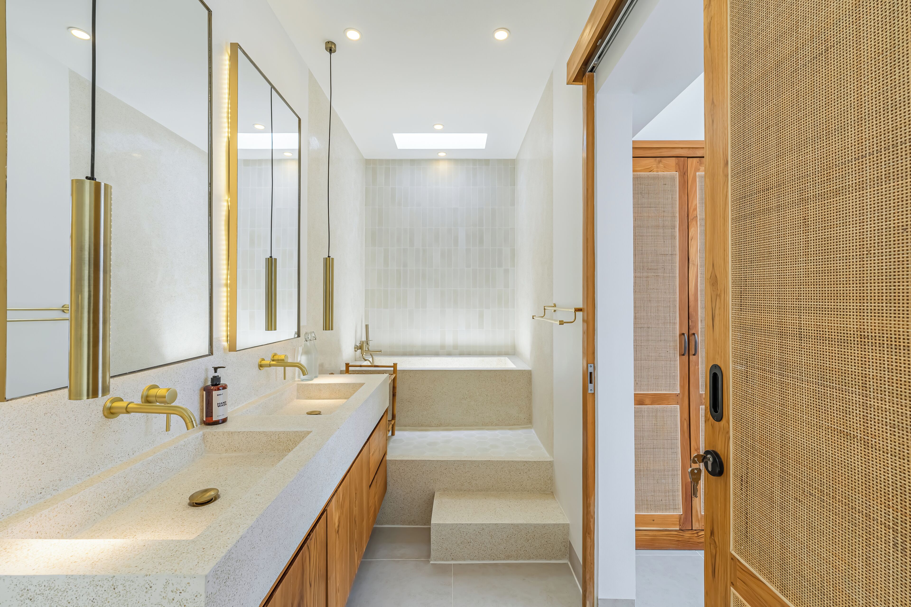 A modern bathroom with dual sinks, a large mirror, and a walk-in shower.