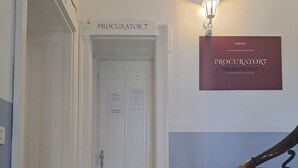 A hallway with a tiled floor, a white door labeled 'PROCURATOR7', and a wall-mounted sign reading 'PROCURATOR7 THAI CENTAR SPLIT'. - 103 luxury room in the heart of Split with roof terrace (Split)