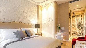 A modern hotel room with a large bed, a small bedside table with a lamp, a red chair, and a wall with a mural. - 103 luxury room in the heart of Split with roof terrace (Split)