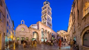 A historic square with a prominent bell tower, a dome, and a covered walkway. - 103 luxury room in the heart of Split with roof terrace (Split)