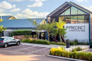Un edificio moderno con un letrero que dice 'The Precinct Lifestyle Hub'.