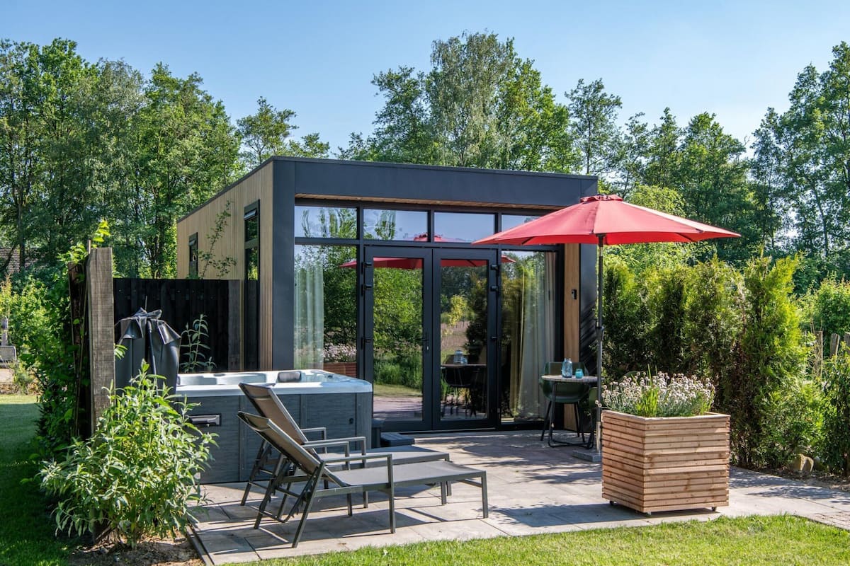 Eine moderne Außenpatio mit Whirlpool, Sitzgelegenheit und einem Holzpflanztopf.