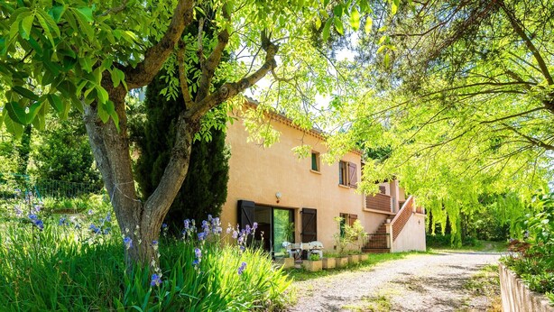 Une maison avec un chemin de terre menant à un escalier en bois.