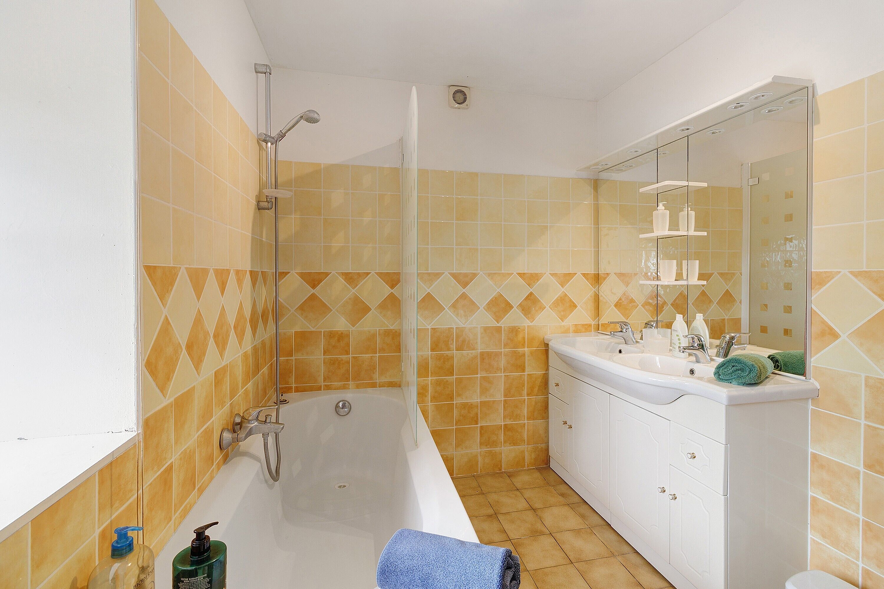 Une salle de bain avec une baignoire, une douche, un lavabo et un miroir.