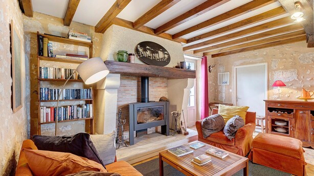 A cozy living room with a fireplace, bookshelves, a sofa, and a coffee table.