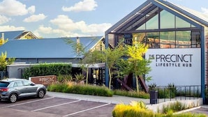 Un edifici modern amb un cartell que diu 'The Precinct Lifestyle Hub'.
