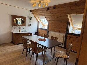 Ein Essbereich mit Holztisch und Stühlen, einem Spiegel und einem Fenster mit Blick.