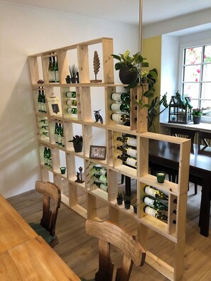 A wooden wine rack with bottles and decorative items. - Spacious family vacation apartment near Cochem (Ernst)