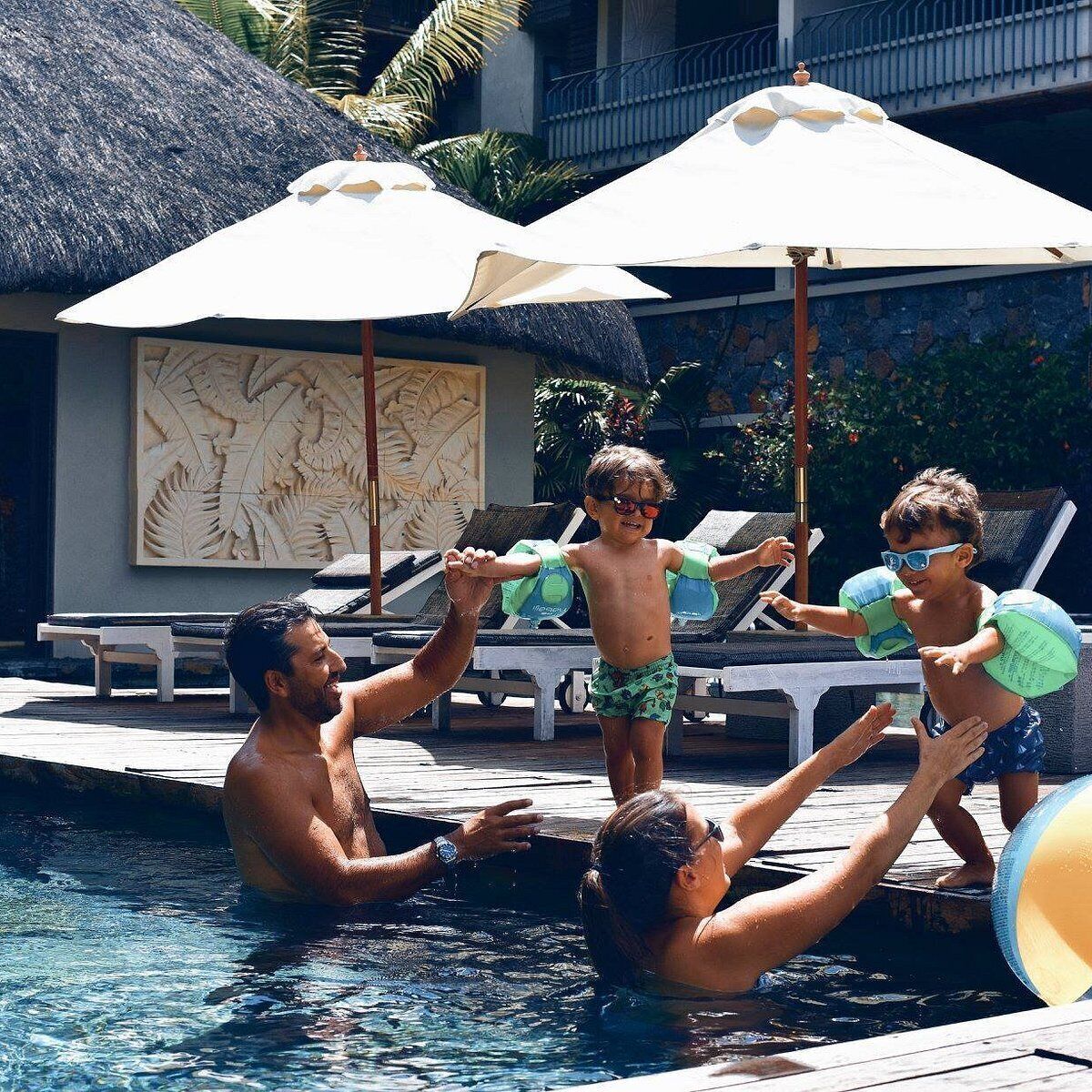Ein Poolbereich mit Liegestühlen und Sonnenschirmen.