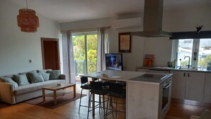 En moderne lejlighed med stue, køkken og spiseområde.