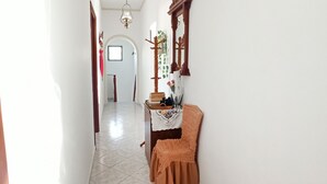 A hallway with a wooden door, a mirror, and a small table with a cloth. - Escape to this Sea View Apartment close to Kalymnos Climbing Routes (KALYMNOS)