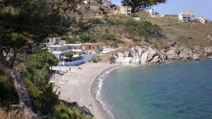 A coastal area with a beach, clear blue water, and buildings in the background. - Escape to this Sea View Apartment close to Kalymnos Climbing Routes (KALYMNOS)