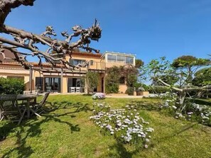 A house with a garden, outdoor furniture, and a clear sky. - Provençal villa by the sea in Les Issambres (Roquebrune-sur-Argens)