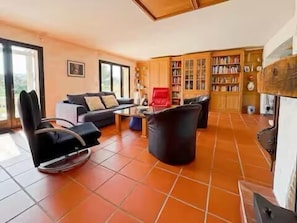 A living room with a sofa, chairs, a coffee table, and a bookshelf. - Provençal villa by the sea in Les Issambres (Roquebrune-sur-Argens)