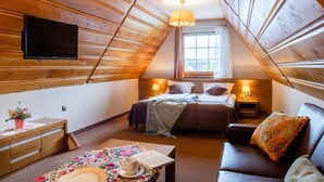 A cozy attic bedroom with a bed, bedside tables, a TV, and a window. - Witowianka (Koscielisko)