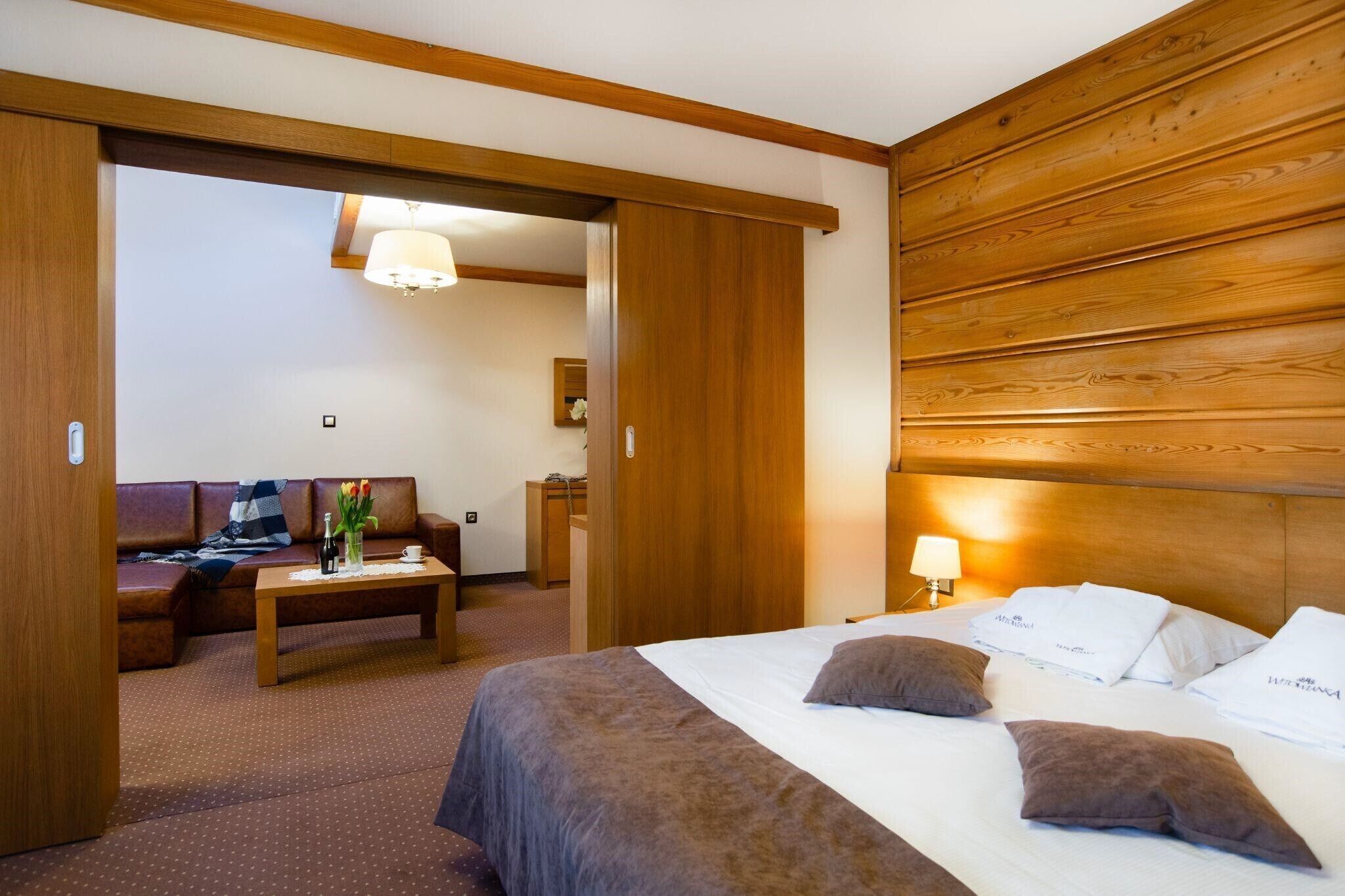 Une chambre d’hôtel avec un lit, un canapé, une table basse et un bureau.