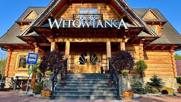 A wooden lodge with a sign reading 'WITOWIANA' and a staircase leading to the entrance. - Witowianka (Koscielisko)