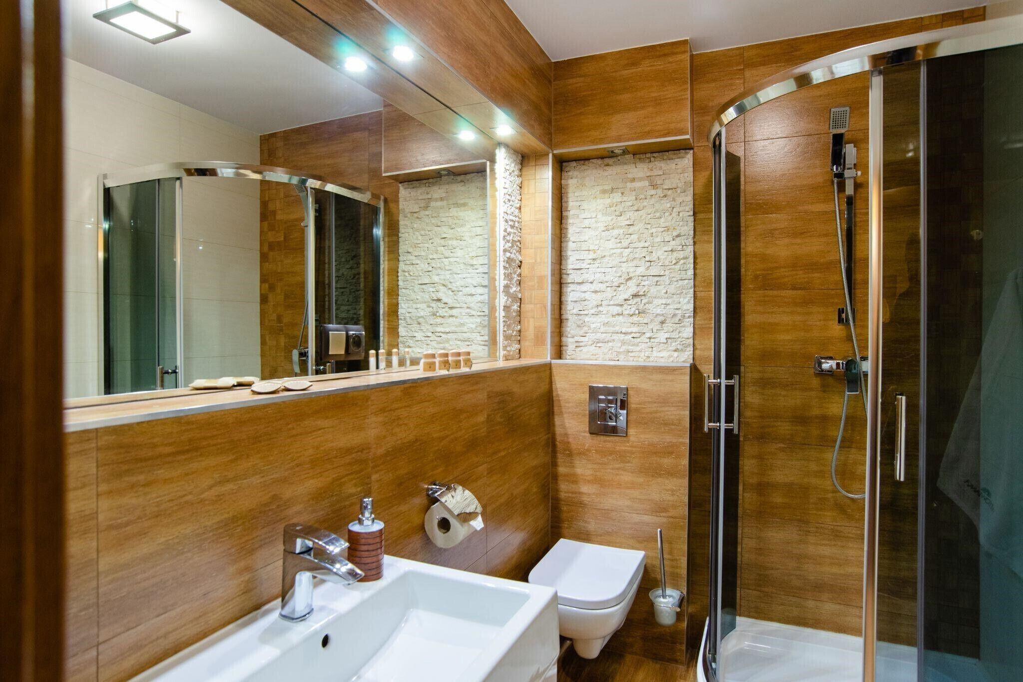 A modern bathroom with a shower, toilet, and sink.