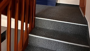 A staircase with wooden railings and a carpeted landing.