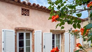 A building with multiple windows, some with shutters, and a tiled roof. - BELLEROSE HOUSE IN HAMLET (Le Plan-de-la-Tour)
