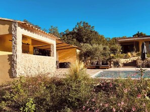 A house with a stone exterior, a patio with outdoor furniture, and a swimming pool. - Mas de la Canopée, pool & air condition (Saint-Saturnin-lès-Apt)