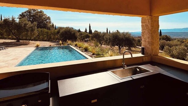 Una cucina moderna con vista su una piscina e sul paesaggio.