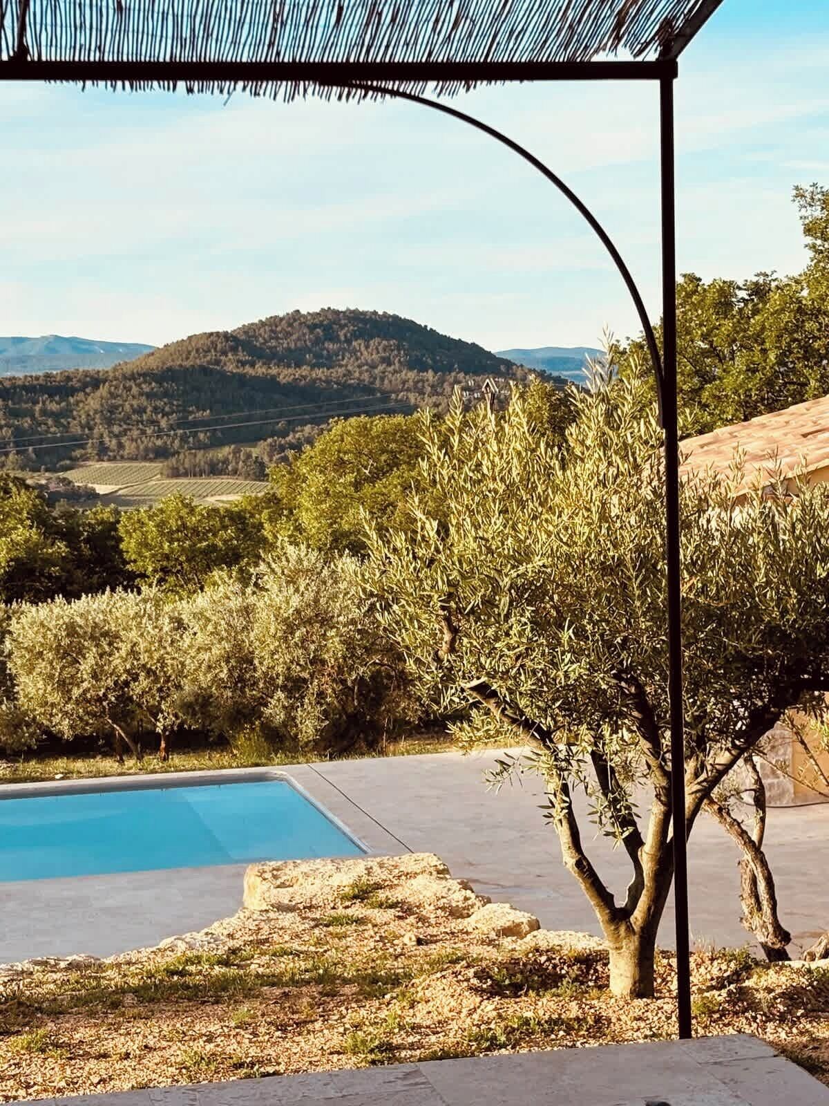 A pool with a view of hills and trees.