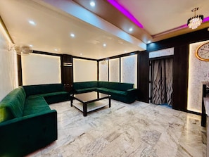 Un salon moderne avec un canapé d’angle, une table basse et un panneau décoratif mural.