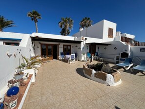 A white building with a patio area, outdoor seating, and potted plants. -  'Puerto Chico F' with Sea View, Wi-Fi and Air Conditioning (CASITAS (LAS)