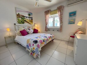 A bedroom with a bed, a nightstand, a lamp, a dresser, a window with curtains, and a wall painting. -  'Puerto Chico F' with Sea View, Wi-Fi and Air Conditioning (CASITAS (LAS)