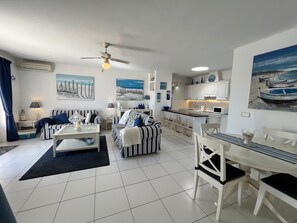A compact living space with a dining area, kitchenette, and a ceiling fan. -  'Puerto Chico F' with Sea View, Wi-Fi and Air Conditioning (CASITAS (LAS)