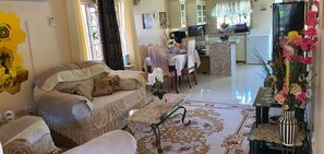 Una sala de estar con sofá, una mesa de centro y un comedor con mesa y sillas.