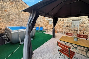 Eine Außenpatio mit Pool, Stühlen und einem Tisch.